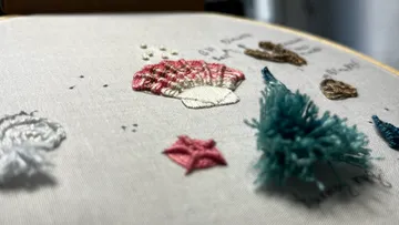 Embroidered shells and stars on bright fabric.