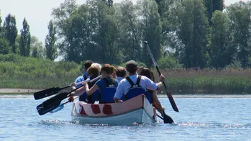 Eine Gruppe von Menschen rudert in einem Boot.