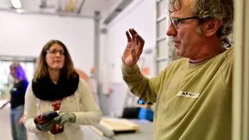 Two people are talking in a workshop.
