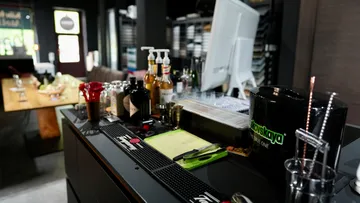 Bar area with various drinks and mixing equipment.