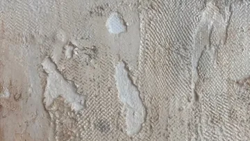 Strukturierte Oberfläche mit abgenutzten Stellen und Farben.