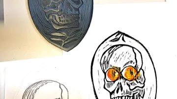 Skull design sign surrounded by sketches and designs