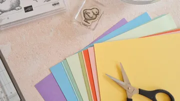 Colourful paper and scissors lie on a table.