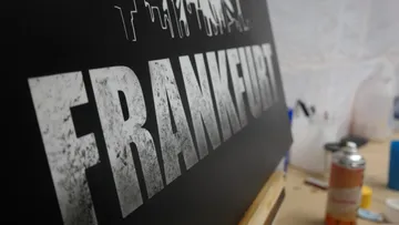 Schwarzschild with the inscription “FRANKFURT” in front of a workshop.