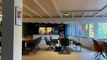 Open-plan apartment with a kitchen and cozy seating areas.