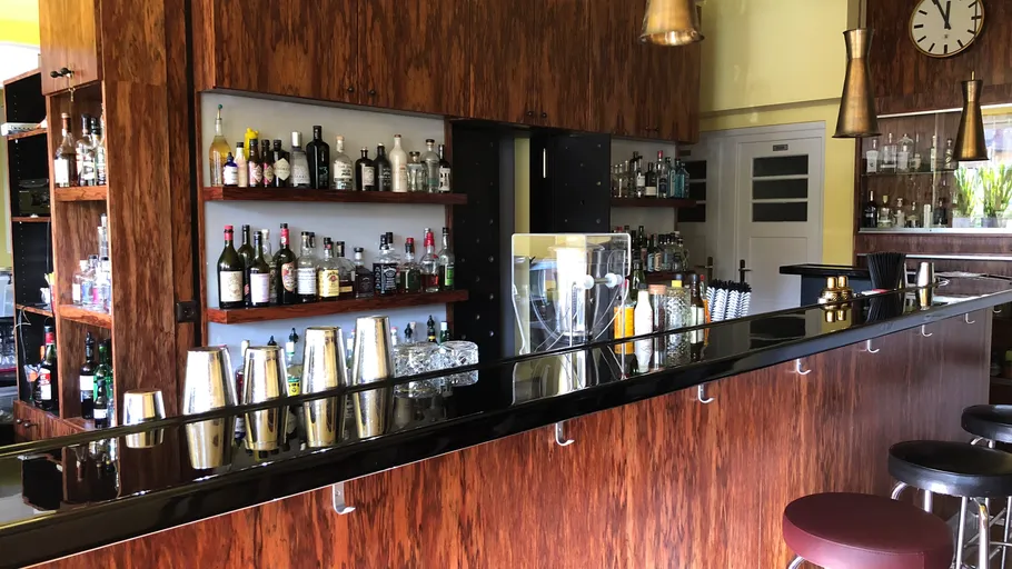 An elegant bar counter with bottles and glassware.