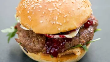 Juicy hamburger with sesame rolls and fruit sauce.
