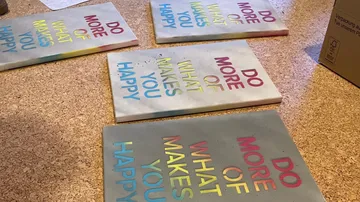 Bunte Platten liegen auf einem Tisch mit inspirierenden Sprüchen.