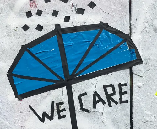 Blue umbrella street art with 'We Care' text.