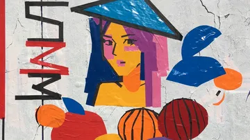 Buntes Wandbild mit abstraktem Frauengesicht und Formen.