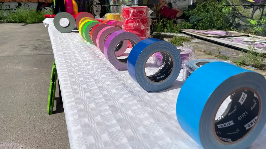 Colorful duct tapes on a white table outdoors.