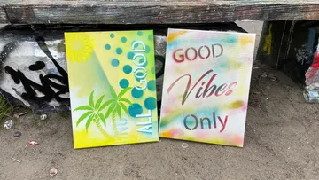 Two painted canvases stand on the floor.