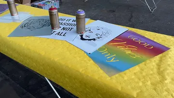 Aerosoldosen liegen auf einem Tisch mit Kunstwerken.