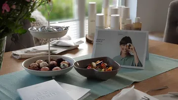 Plate with snacks, someone shows a product in a brochure.
