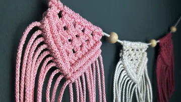Hanging macrame decoration features knotted patterns on wall
