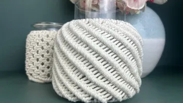 Korblike Objekte stehen neben einer Vase mit Blumen.