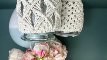 Geflochtene Gläser hängen über einer blühenden Blumenarrangement.
