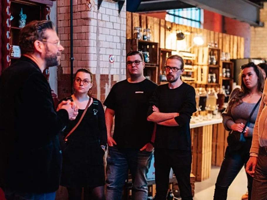 Ein Mann spricht zu einer Gruppe in einem stilvollen Raum.