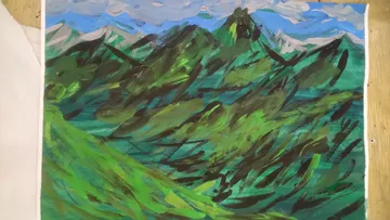 Grüne Berge unter einem blauen Himmel mit Wolken.