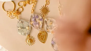Schmuckstück mit getrockneten Blumen, glänzend in goldener Kette.