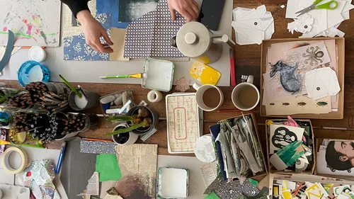 Table with craft materials, cups and active work.
