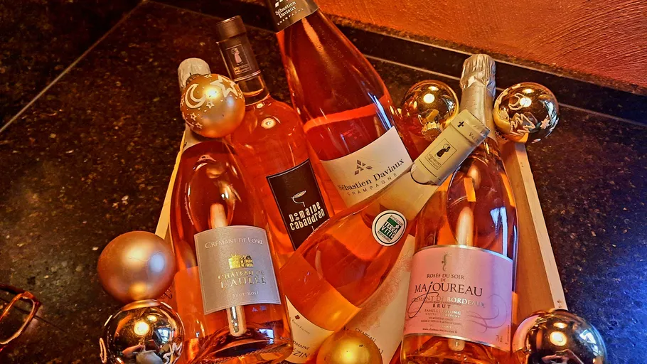 Flaschen Roséwein in einer dekorativen Box mit Weihnachtskugeln.