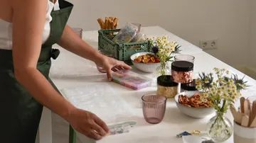 A person arranges food on a table.