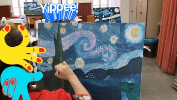 A person enthusiastically paints on a canvas in a room.