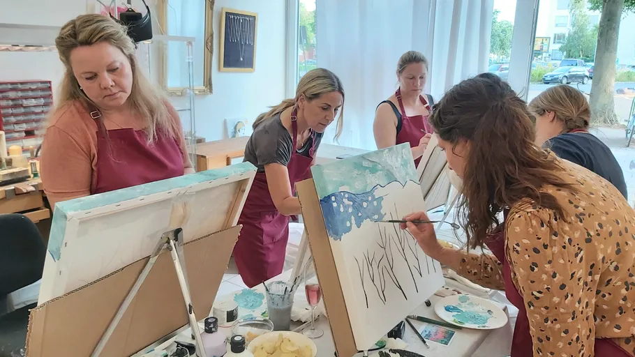 Frauen malen mit Pinsel auf Leinwänden in einem Atelier.