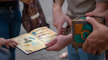 The book and box are examined by several people.