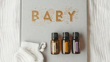 Essential oils are on a baby book with decorative motifs.