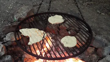 A grill with bread over an open fire.