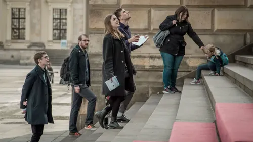 Group of people climb stairs; some watch the surrounding area.