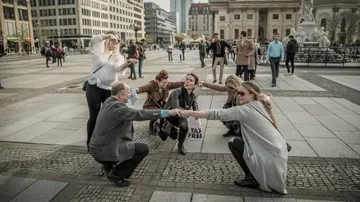 Gruppe posiert spielerisch auf dem Platz in der Stadt.