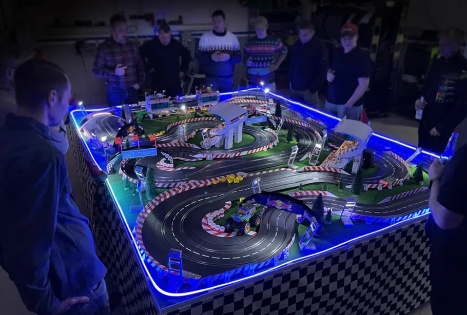 Race track with cars surrounded by curious spectators.