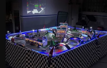 Model racetrack with glowing cars and tracks in space.