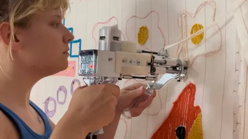 Woman uses a device to create wall decoration.