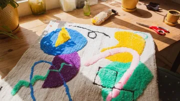 Bunte Teppichoberfläche mit geometrischen Mustern auf einem Tisch.