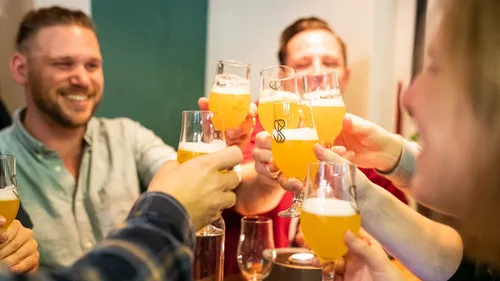 Glasses of beer are toasted at a ceremony.