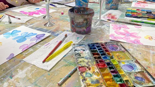 Aquarellfarben werden auf Papier verwendet, um Blumen zu malen.