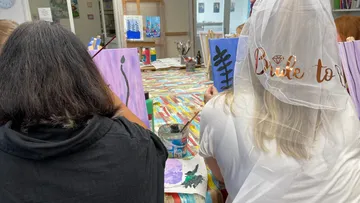 Zwei Frauen malen bei einem kreativen Workshop im Gruppenraum.