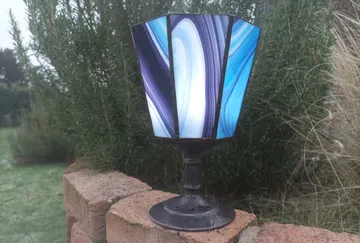 Farbenfrohe Lampe steht auf einem Ziegelsteinmauer.