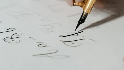 A fountain pen writes elegant letters on paper.