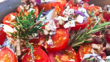 Tomatoes and onions are freshly cut and seasoned.