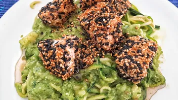 Sesame-crusted fish sits on green zucchini noodles.