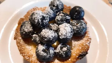 Heidelbeeren bedecken ein süßes Dessert auf einem Teller.