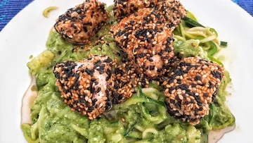 Sesame crusted fish lies on green vegetable puree.