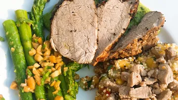 Tender meat, asparagus, couscous, served on a plate.