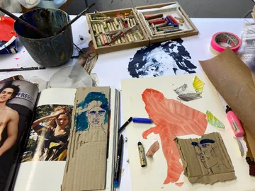 Art materials lie on a table, drawings are created.