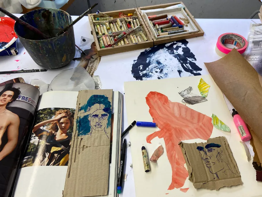 Art materials lie on a table, drawings are created.